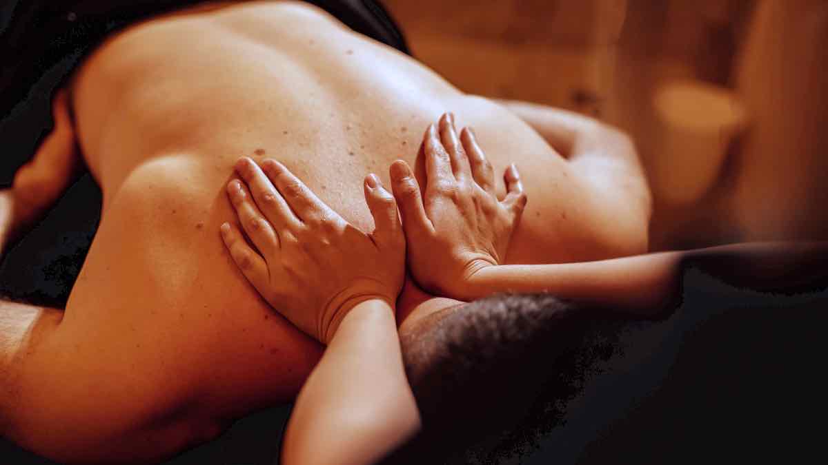 Thai massage and pressure points by an experienced therapist on a man upper back in aluxury villa