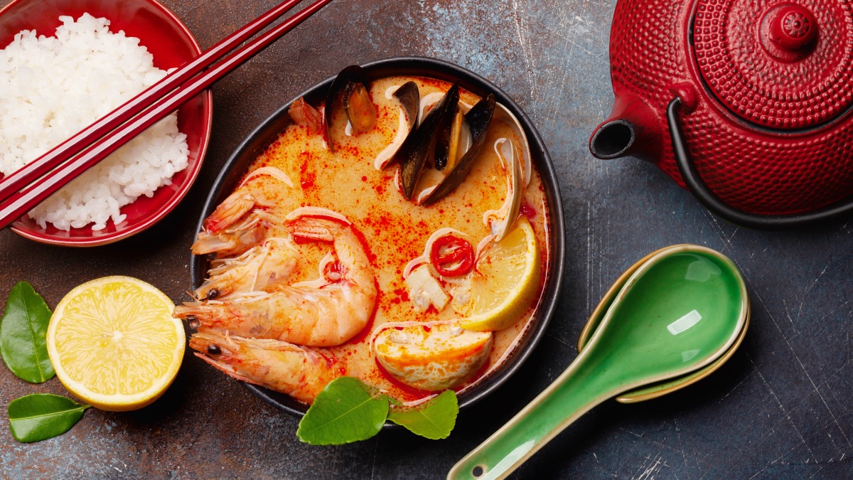 Traditional thai food with spicy soup and rice on a nice dark table top